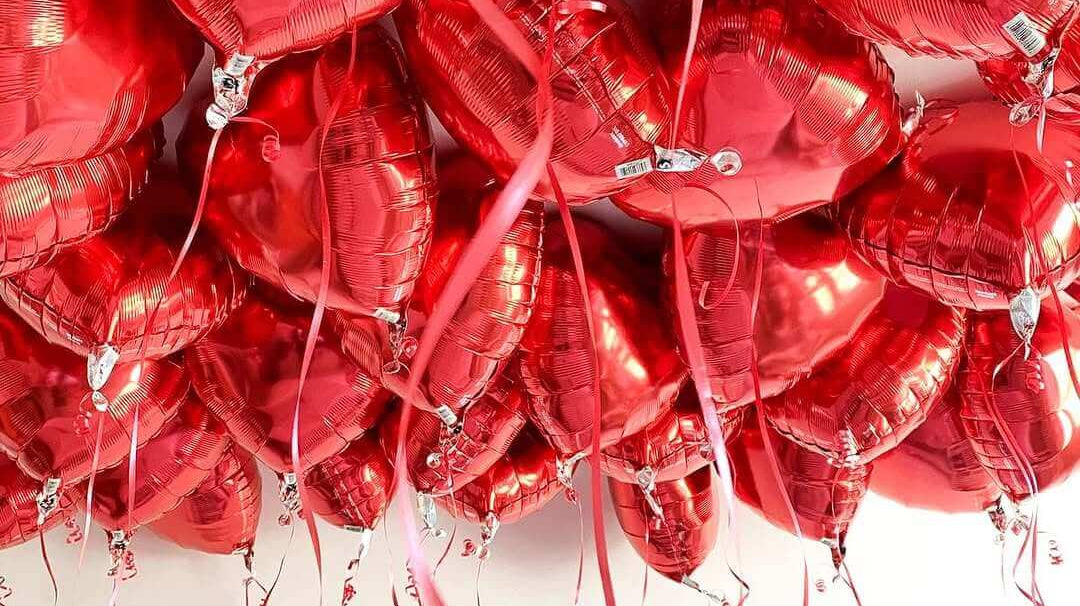 "Red heart foil balloons for Valentine's Day - romantic party decorations with ribbons