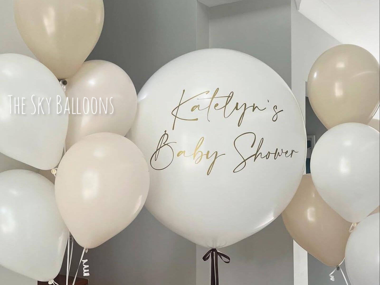 Personalized baby shower balloons in elegant cream and beige colors with custom Katelyn's Baby Shower message, delivered in Dubai