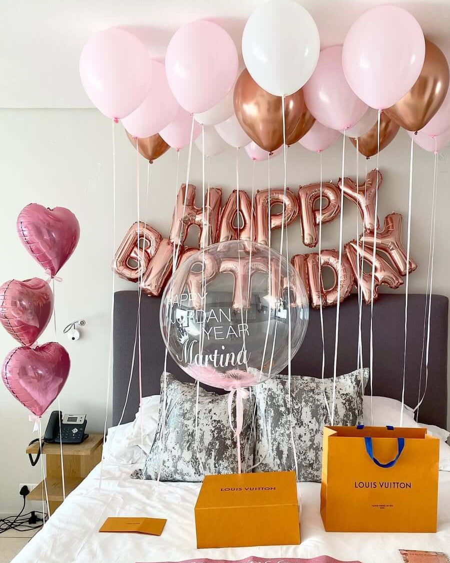 Decorative balloons with 'Happy Birthday 35' on a bed in a room.