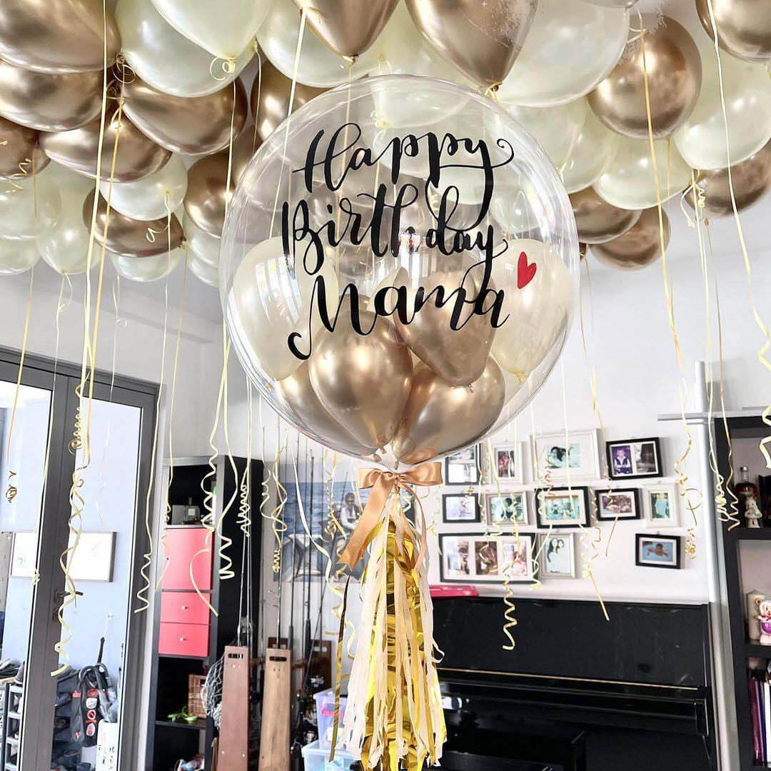 A set of balloons spelling out 'Happy Birthday' with a customized name 'Nathan', in gold and silver colors, displayed in a room.