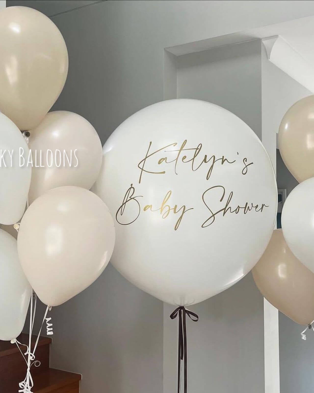 Decorative balloons with 'Katelyn's Baby Shower' text against a neutral background