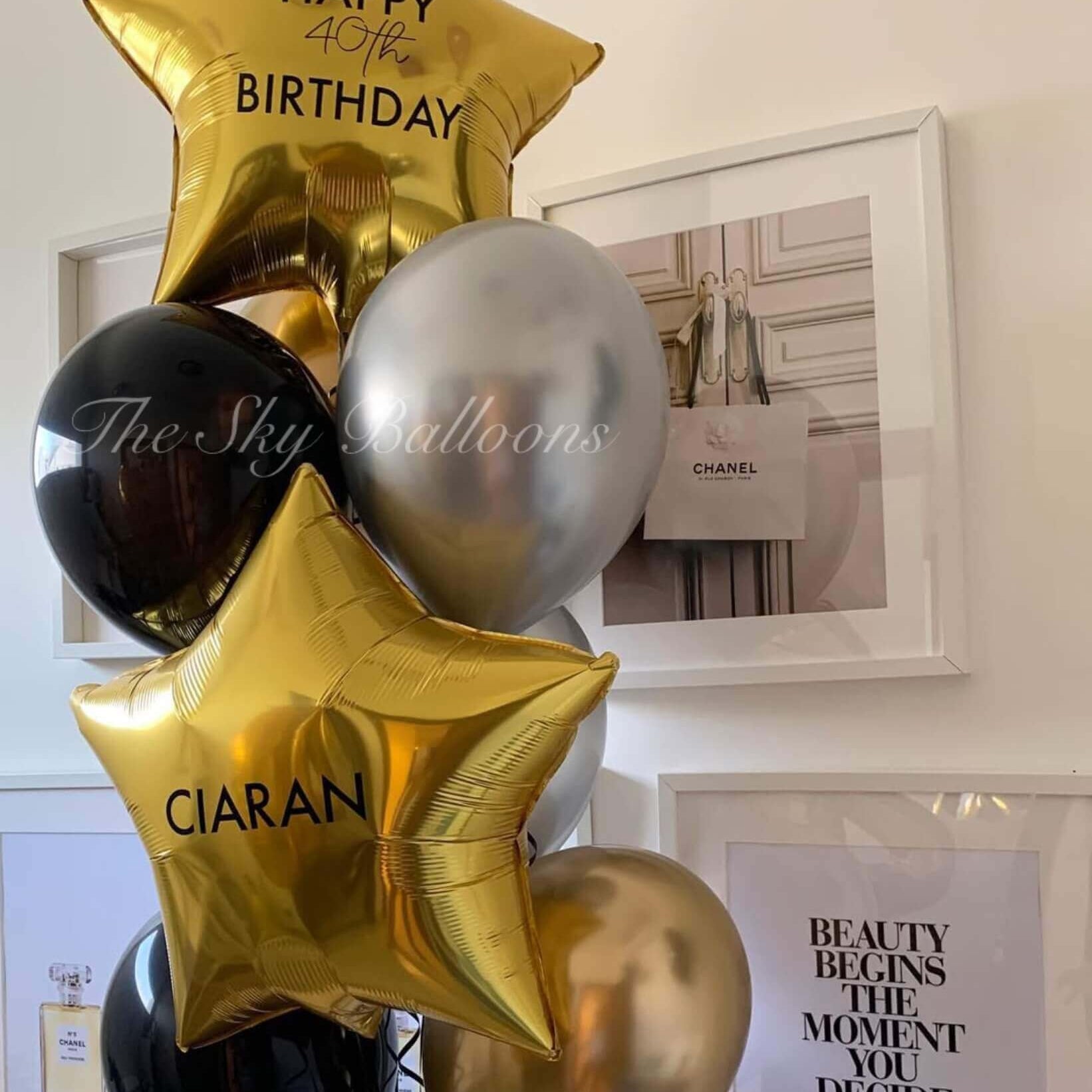 Balloon bouquet with 'Happy 40th Birthday Ciaran' text in a room setting.