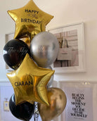 Balloon bouquet with 'Happy 40th Birthday Ciaran' text in a room setting.