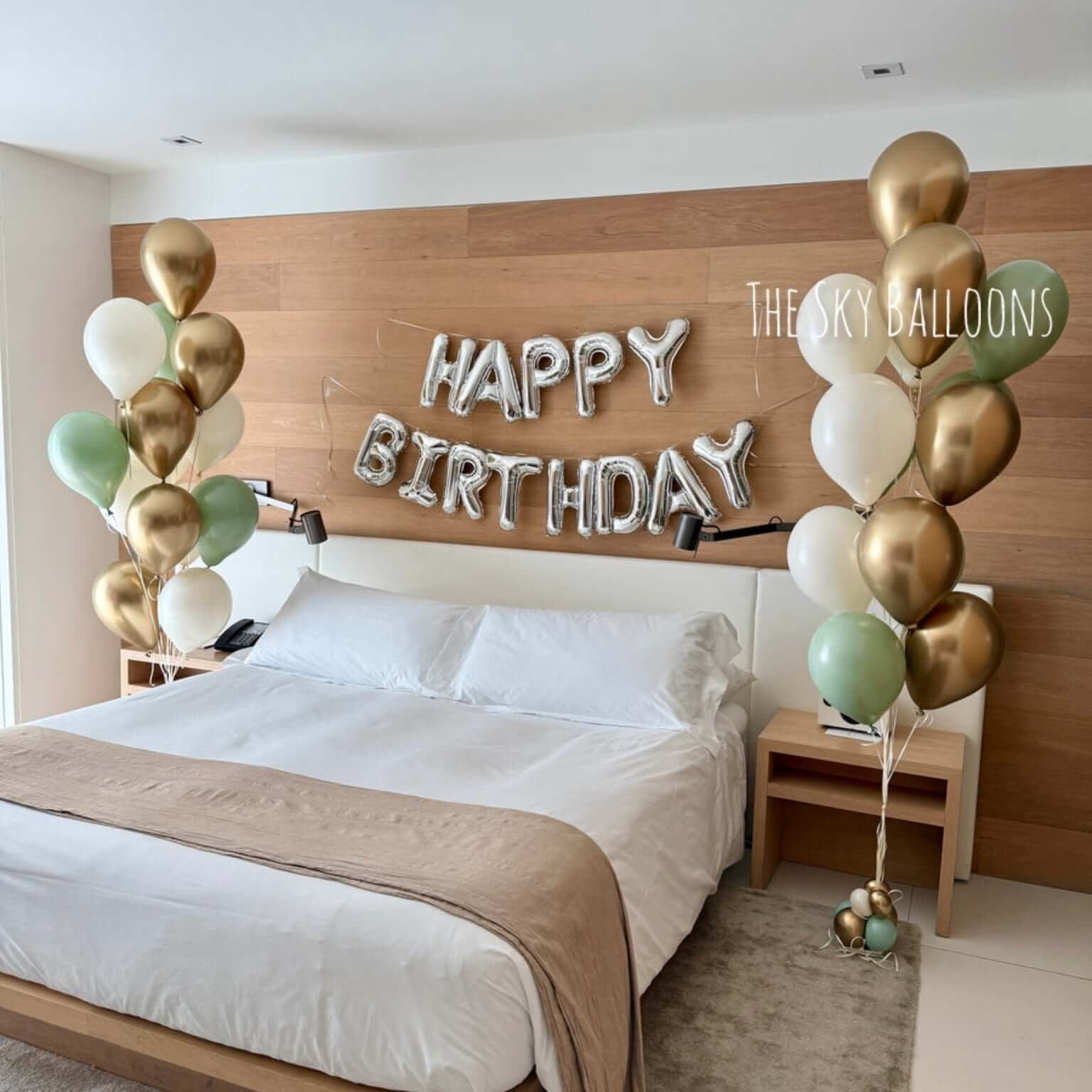 Bedroom with 'Happy Birthday' balloons and wooden headboard