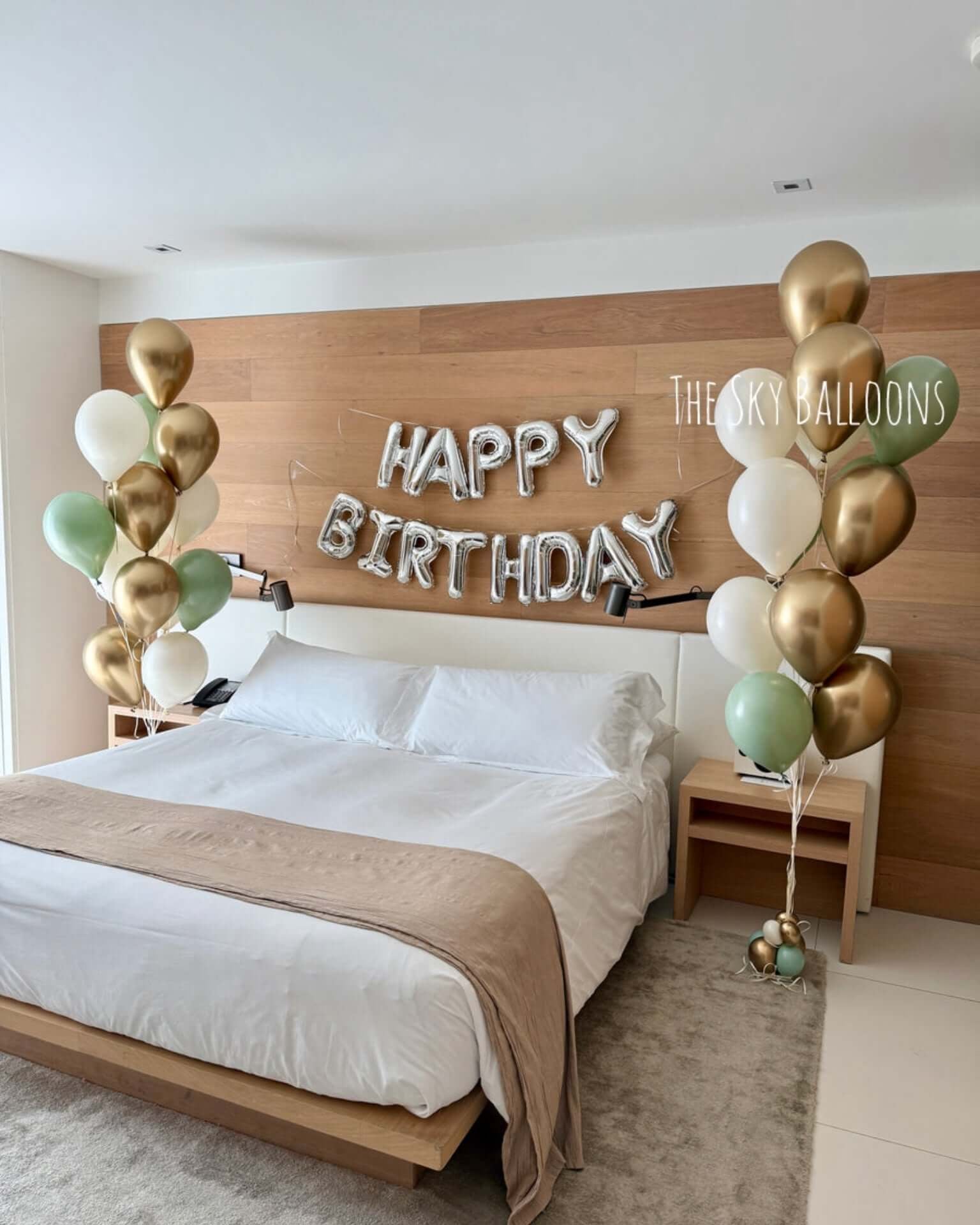 Bedroom with 'Happy Birthday' balloons and wooden headboard