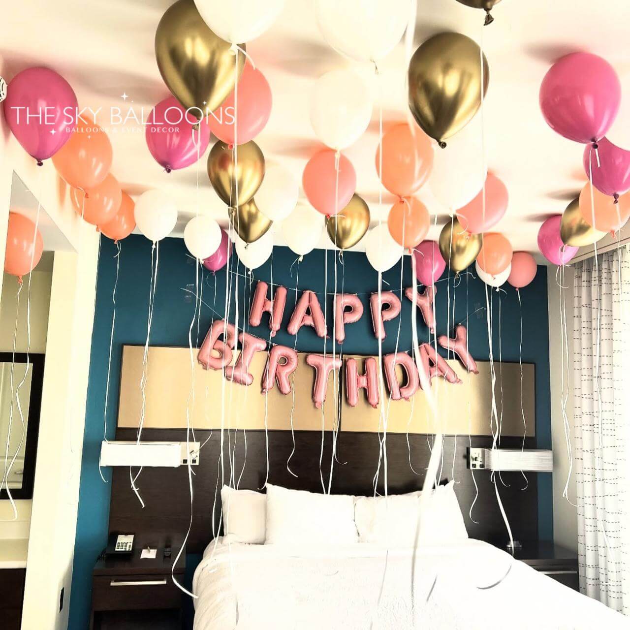 Bedroom with 'Happy Birthday' balloons and a bed in the foreground