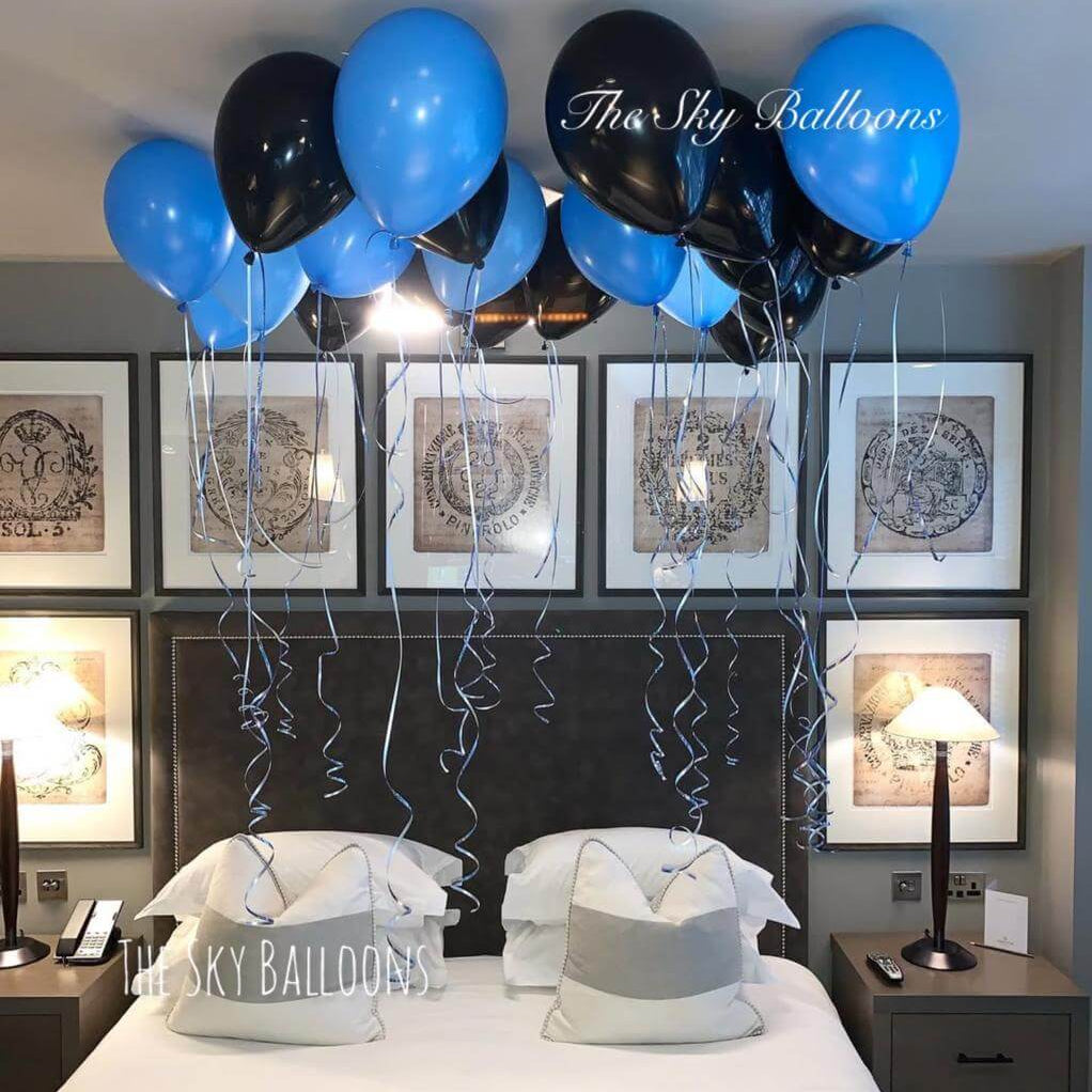 Black and blue ceiling balloon installation in fashionable party decor arrangement