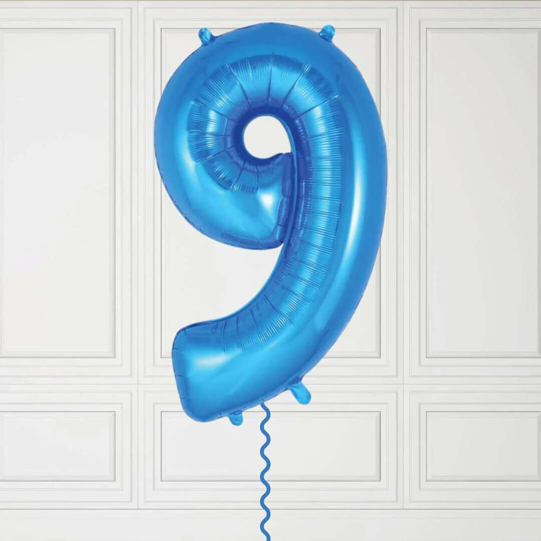 Blue number 9 balloon against a white paneled wall