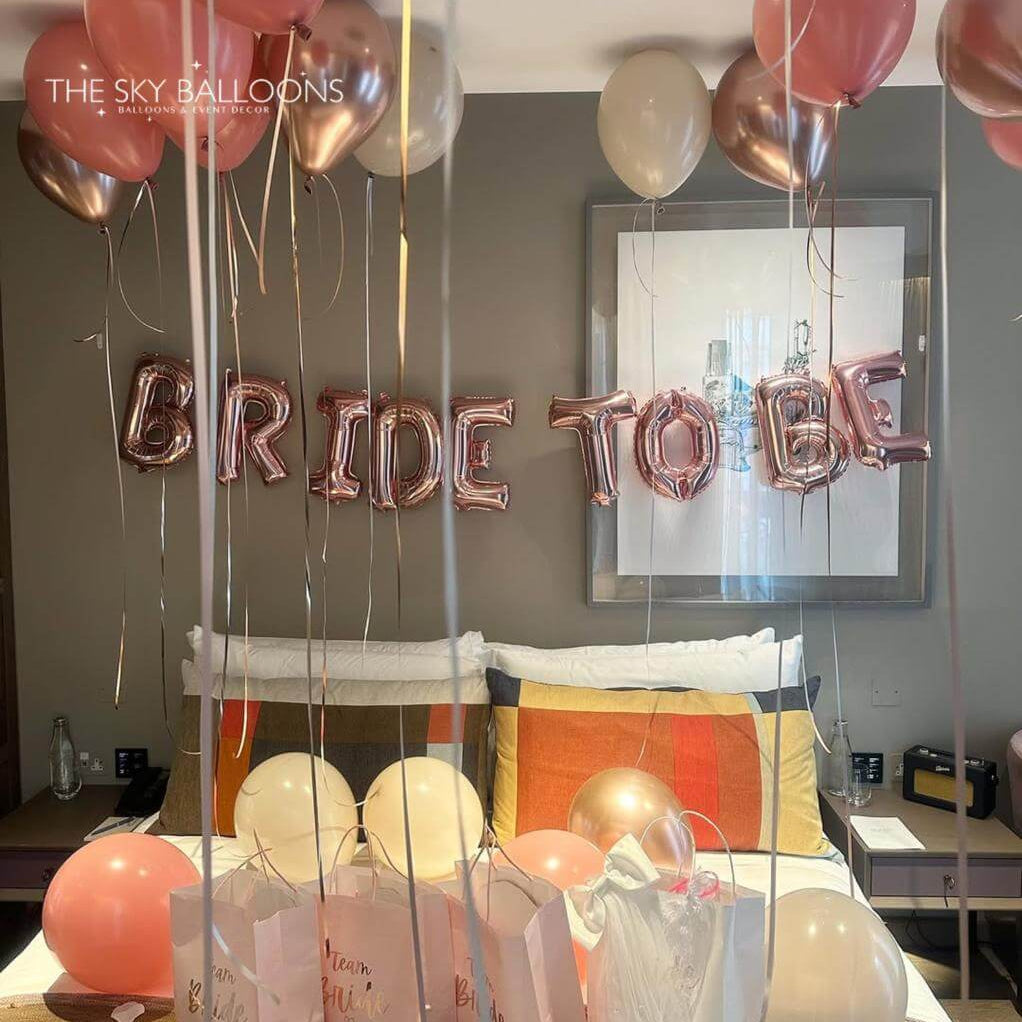 Decorative setup with 'BRIDE TO BE' balloons and balloons in a room.