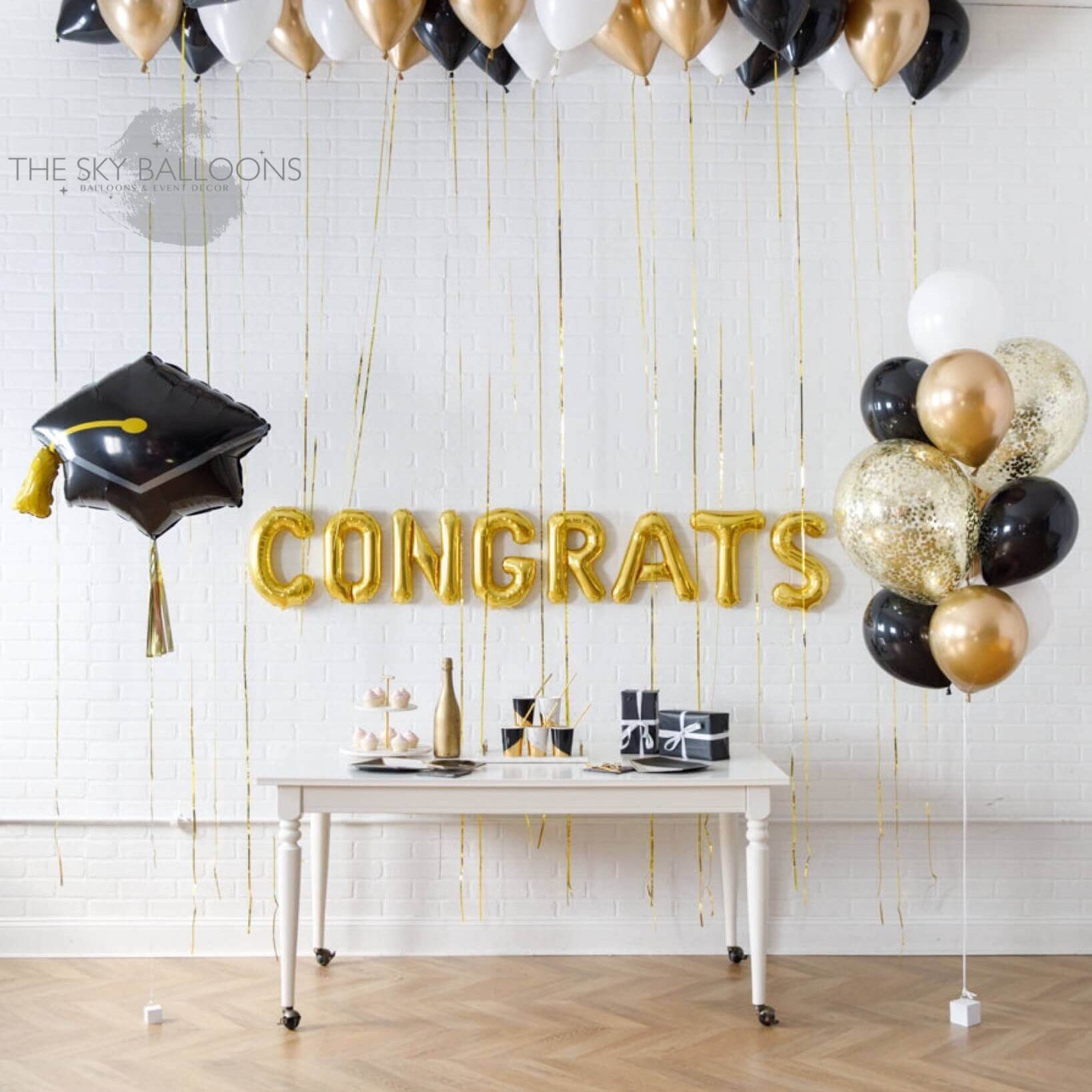 Graduation celebration with a mix of gold and black balloons, creating a festive atmosphere.