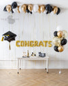 Graduation celebration with a mix of gold and black balloons, creating a festive atmosphere.