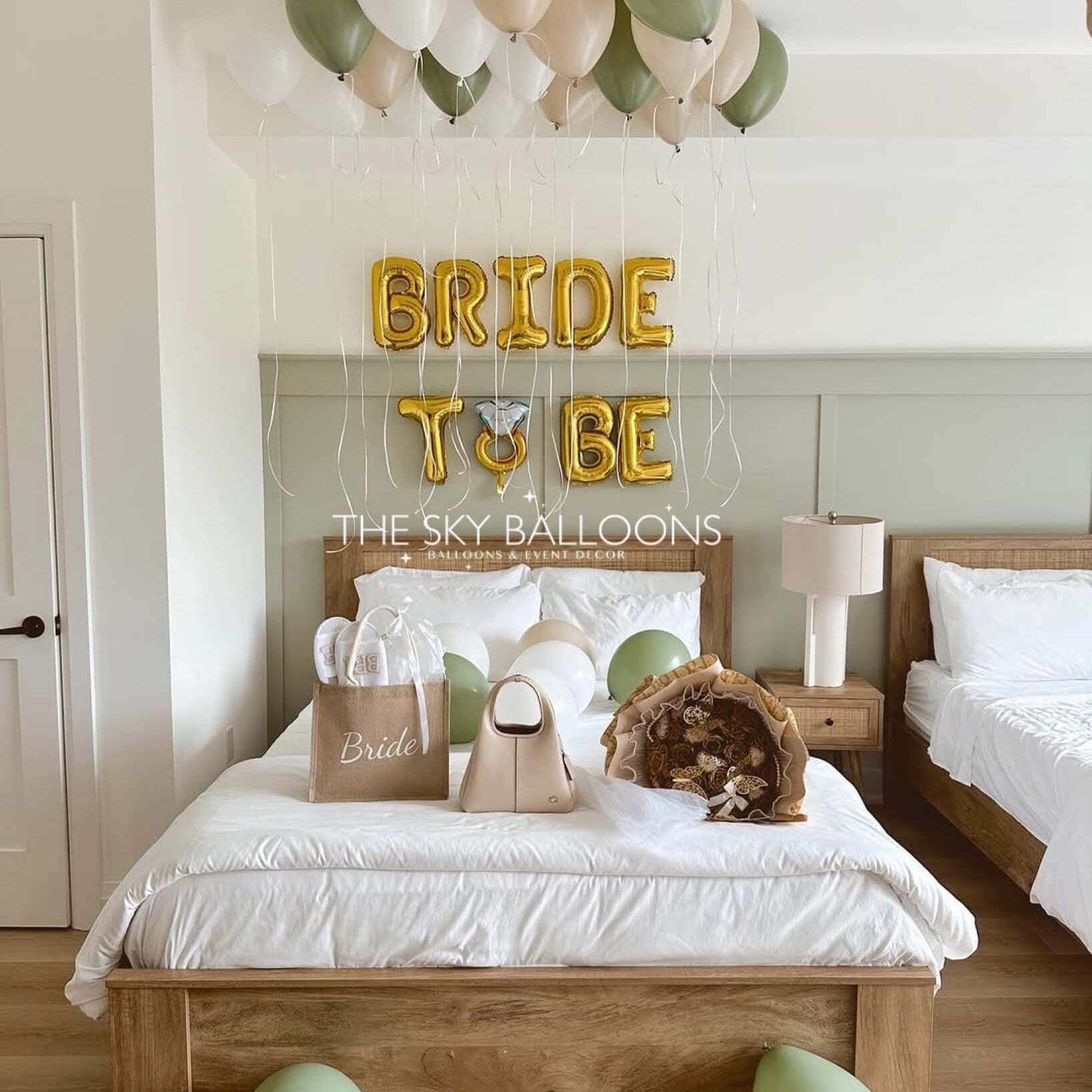 Decorated bedroom with 'Bride to Be' balloons and a bed with white bedding.