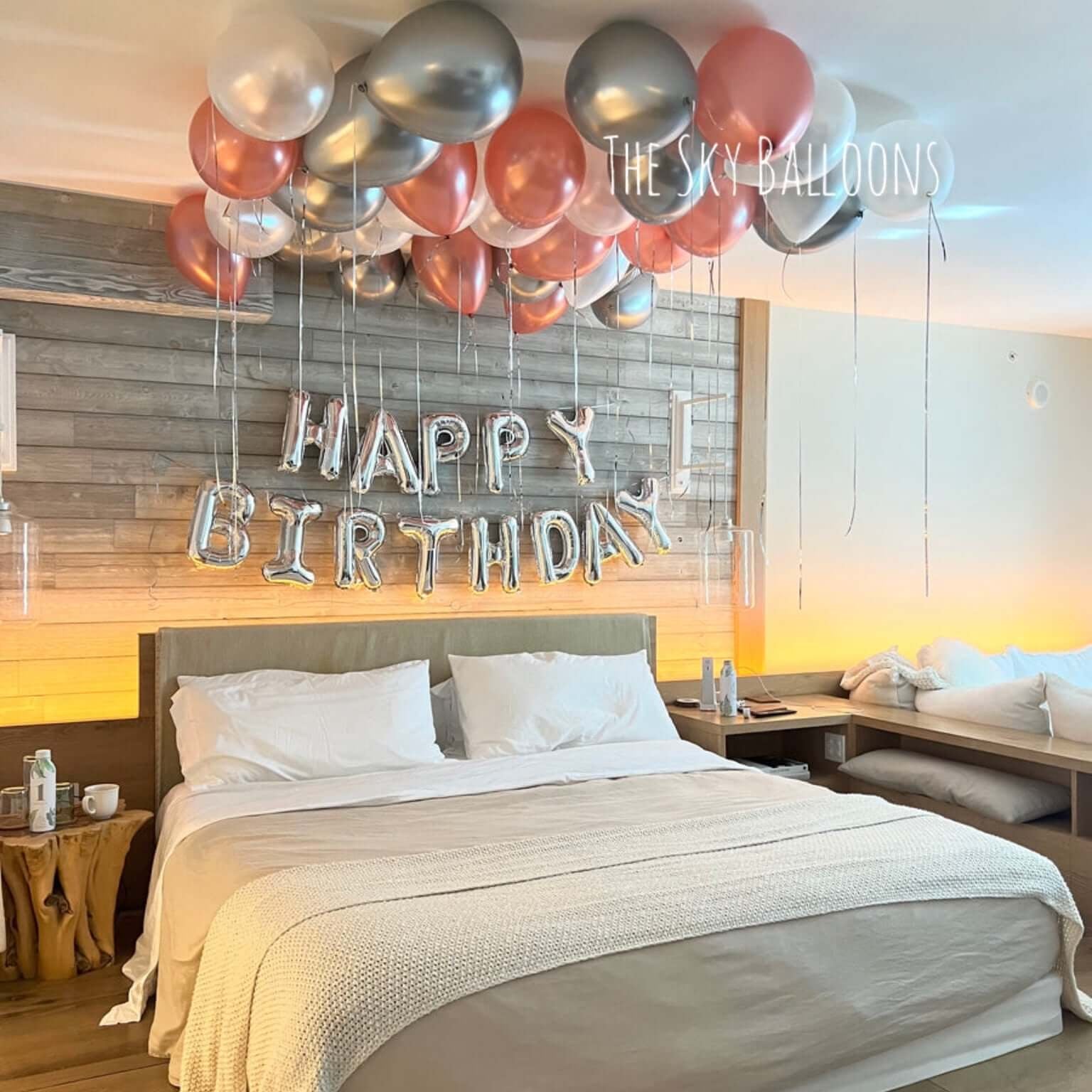 Decorated bedroom with balloons and 'Happy Birthday' sign
