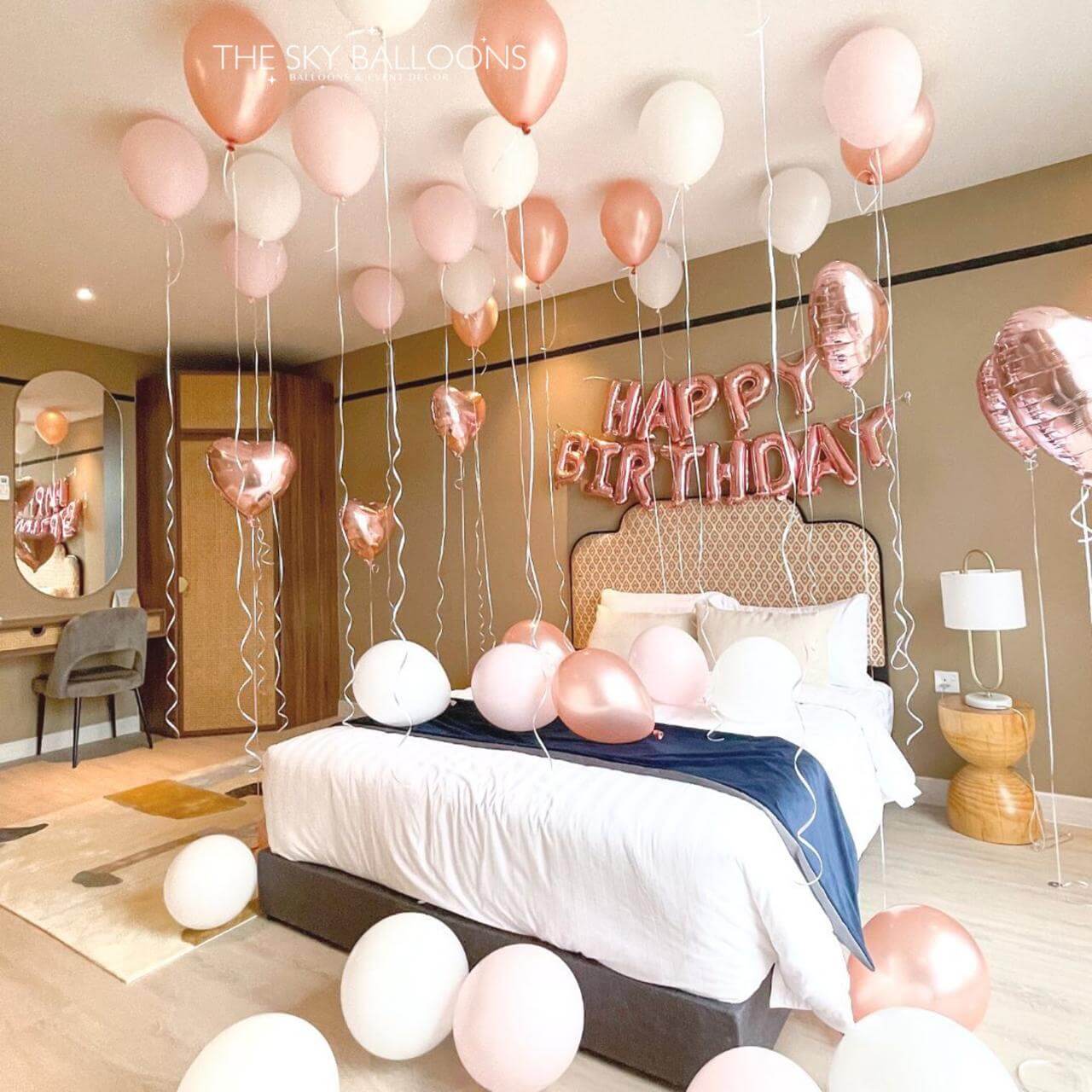 Decorated bedroom with balloons and 'Happy Birthday' sign