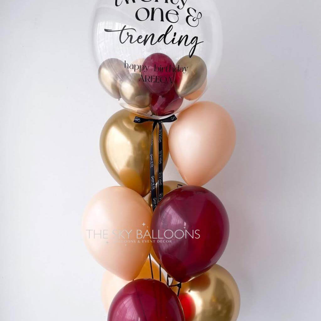 Decorative balloon bouquet with 'twenty one & trending' text on a white background