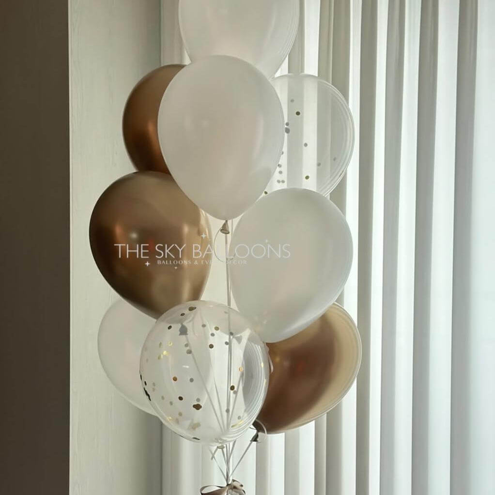 Decorative balloons in gold, white, and clear with 'The Sky Balloons' branding against a window.