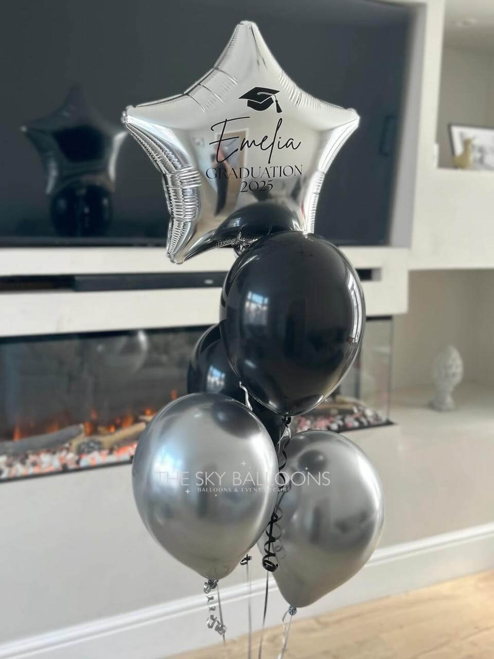 Decorative balloons with 'Evelina Graduation 2023' text in a home setting.