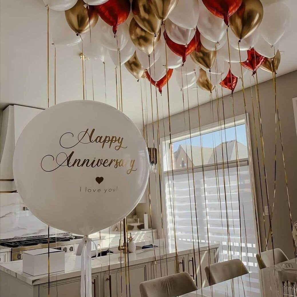 Decorative balloons with 'Happy Anniversary I love you' sign in a kitchen.