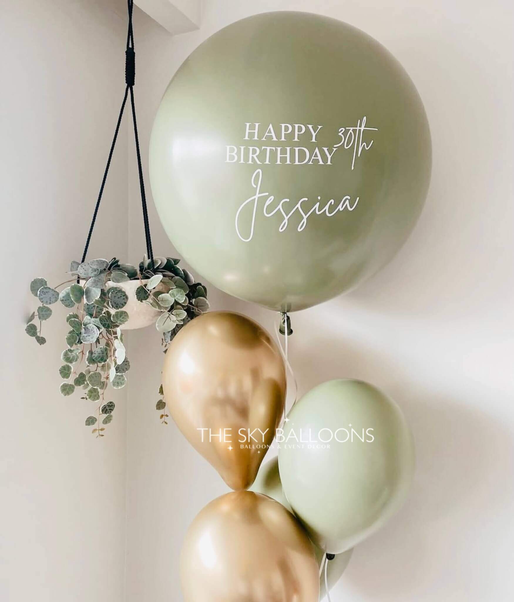 Decorative balloons with 'Happy Birthday Jessica' text and greenery on a light background