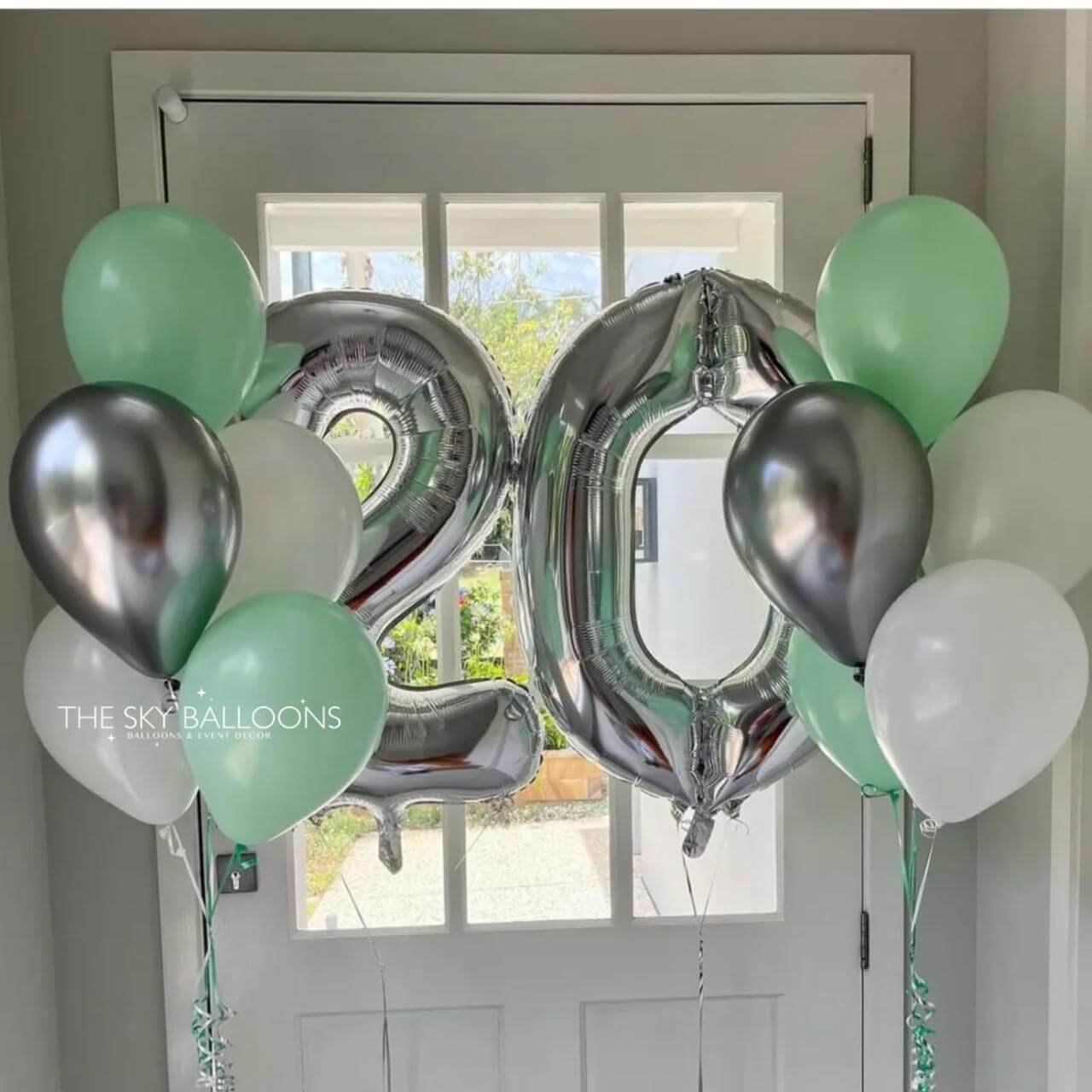 Decorative balloons with numbers '20' and colored balloons in front of a door.