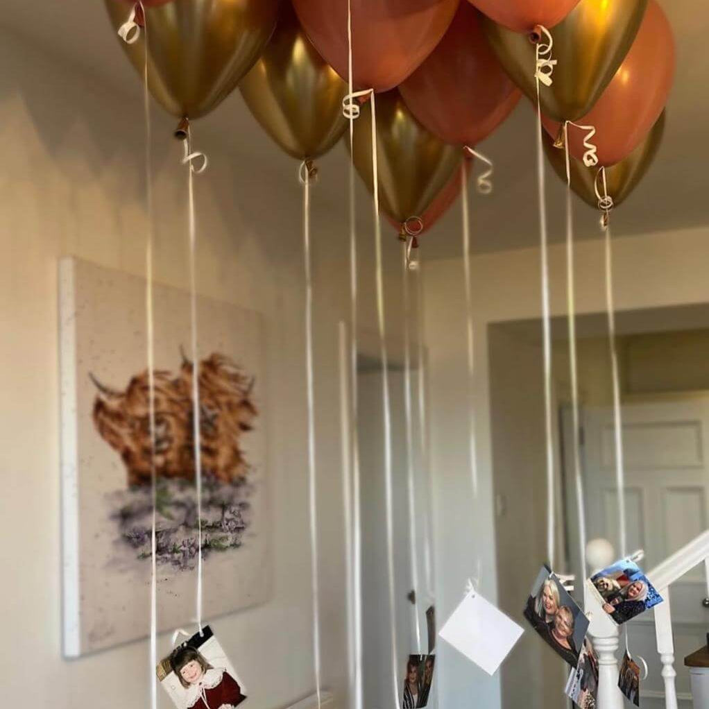 Decorative balloons with strings hanging from the ceiling in a room.