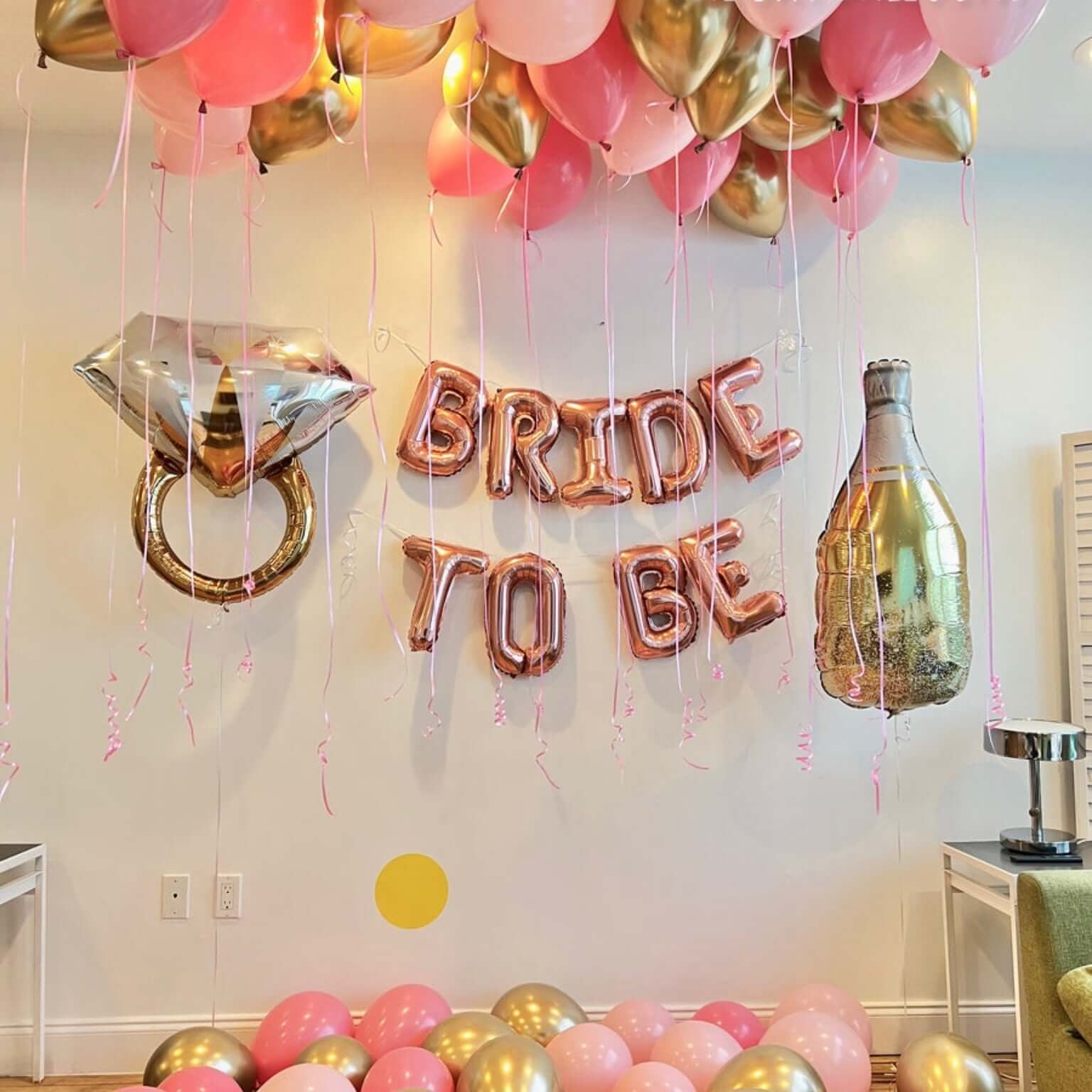 Decorative setup with balloons and 'Bride to Be' letter balloons in a room.