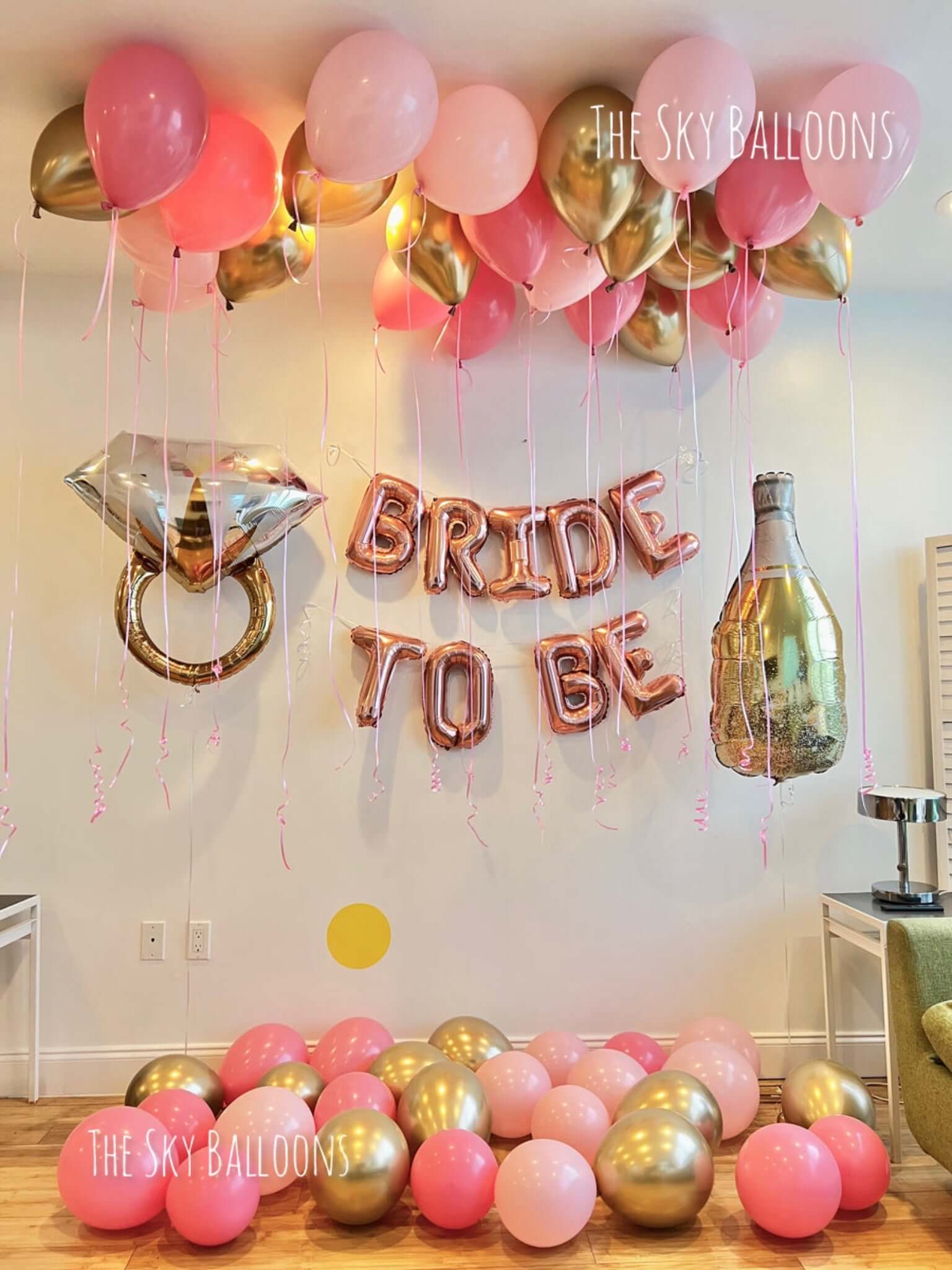 Decorative setup with balloons and 'Bride to Be' letter balloons in a room.