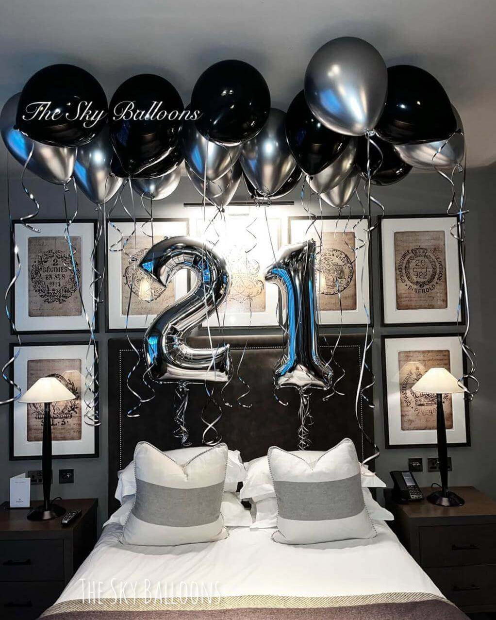 Happy 21st birthday balloon arrangement featuring black and silver balloons in an elegant party setup