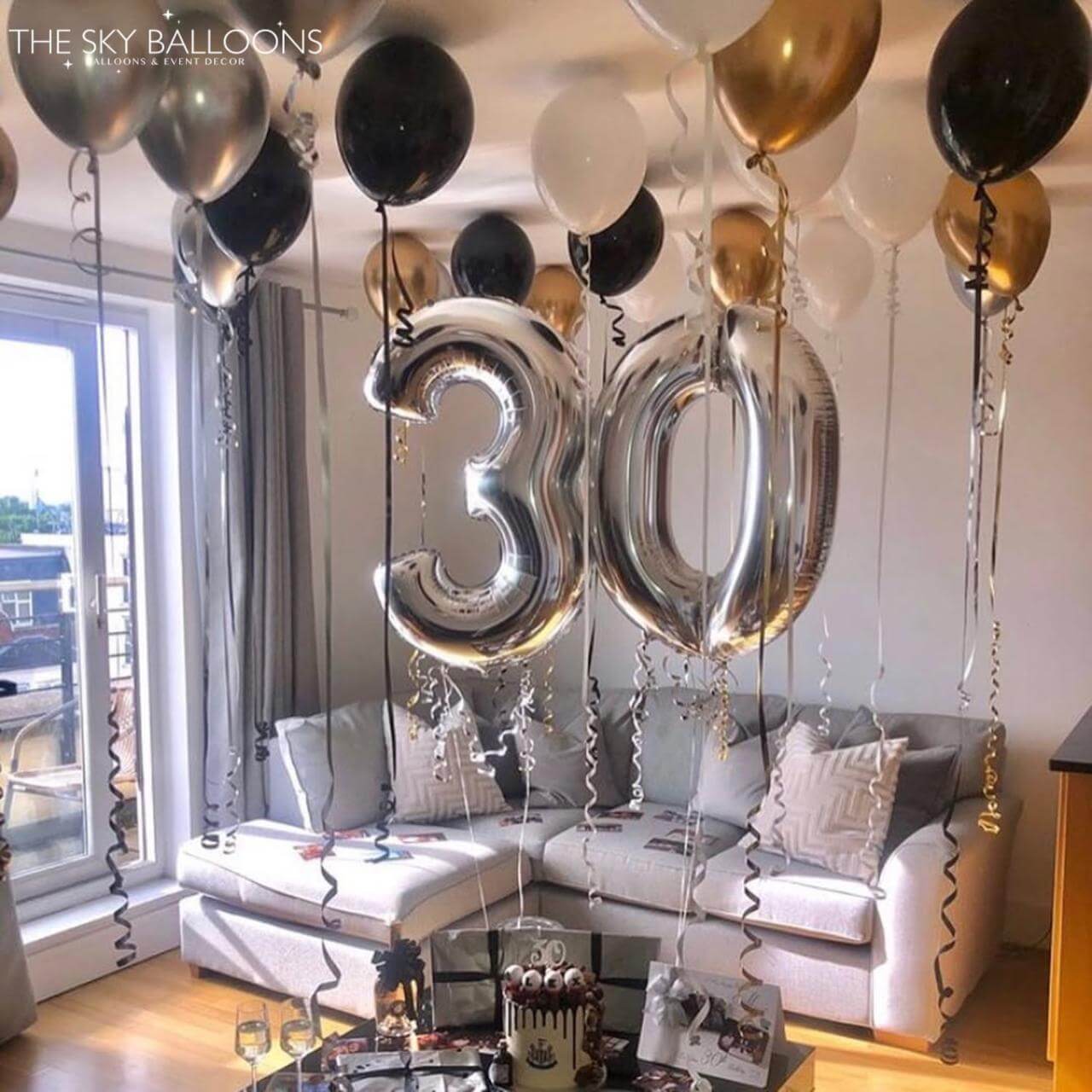 Decorative balloons with the number '30' in a living room setting.