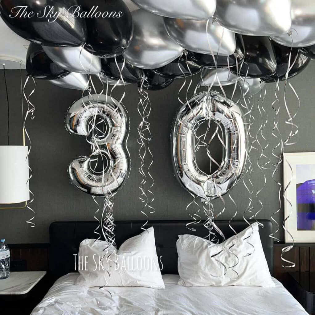 Happy 30th birthday balloon arrangement in colorful party setup