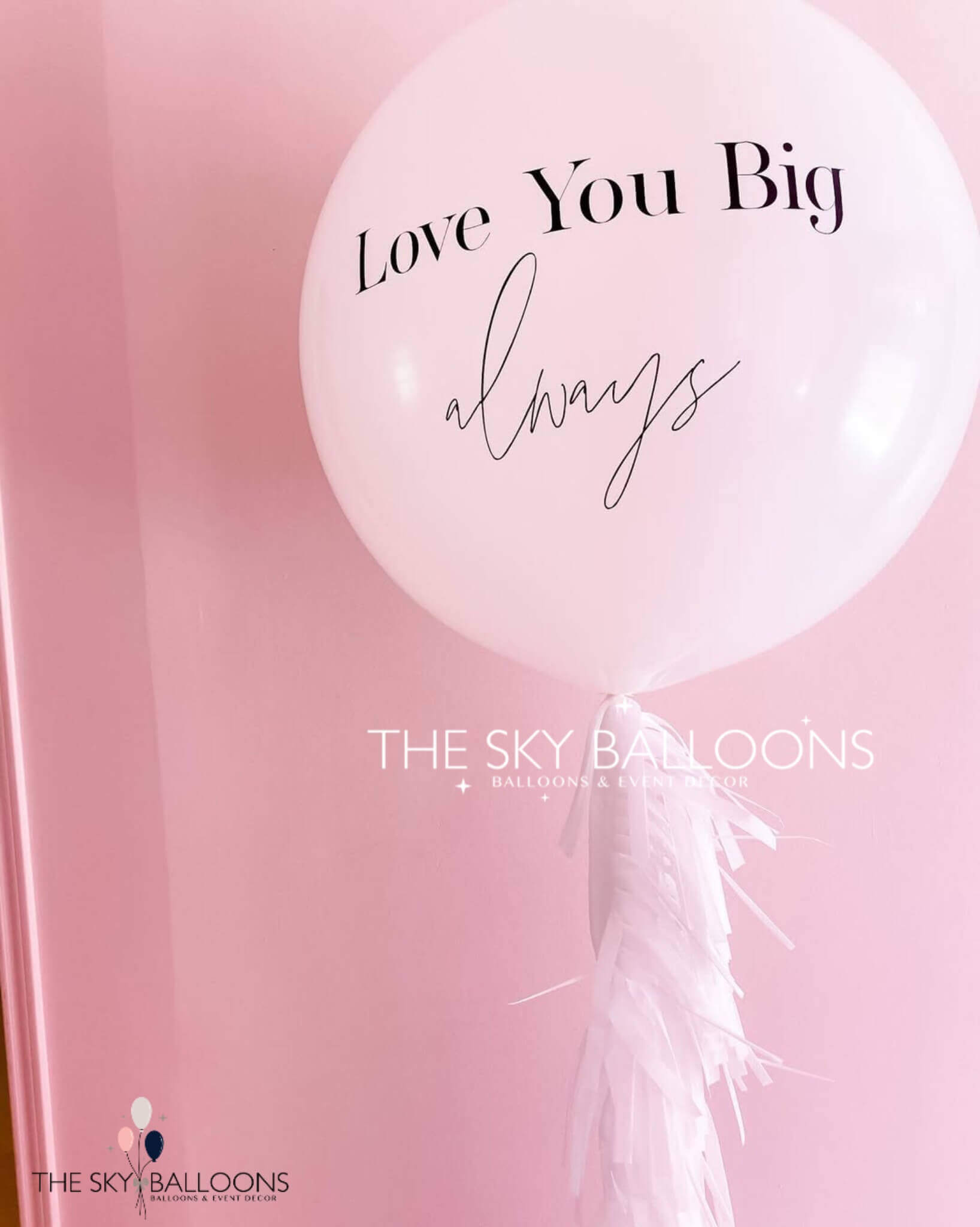 large balloon with the phrase "Love You Big Always" printed in colorful letters against a bright background.