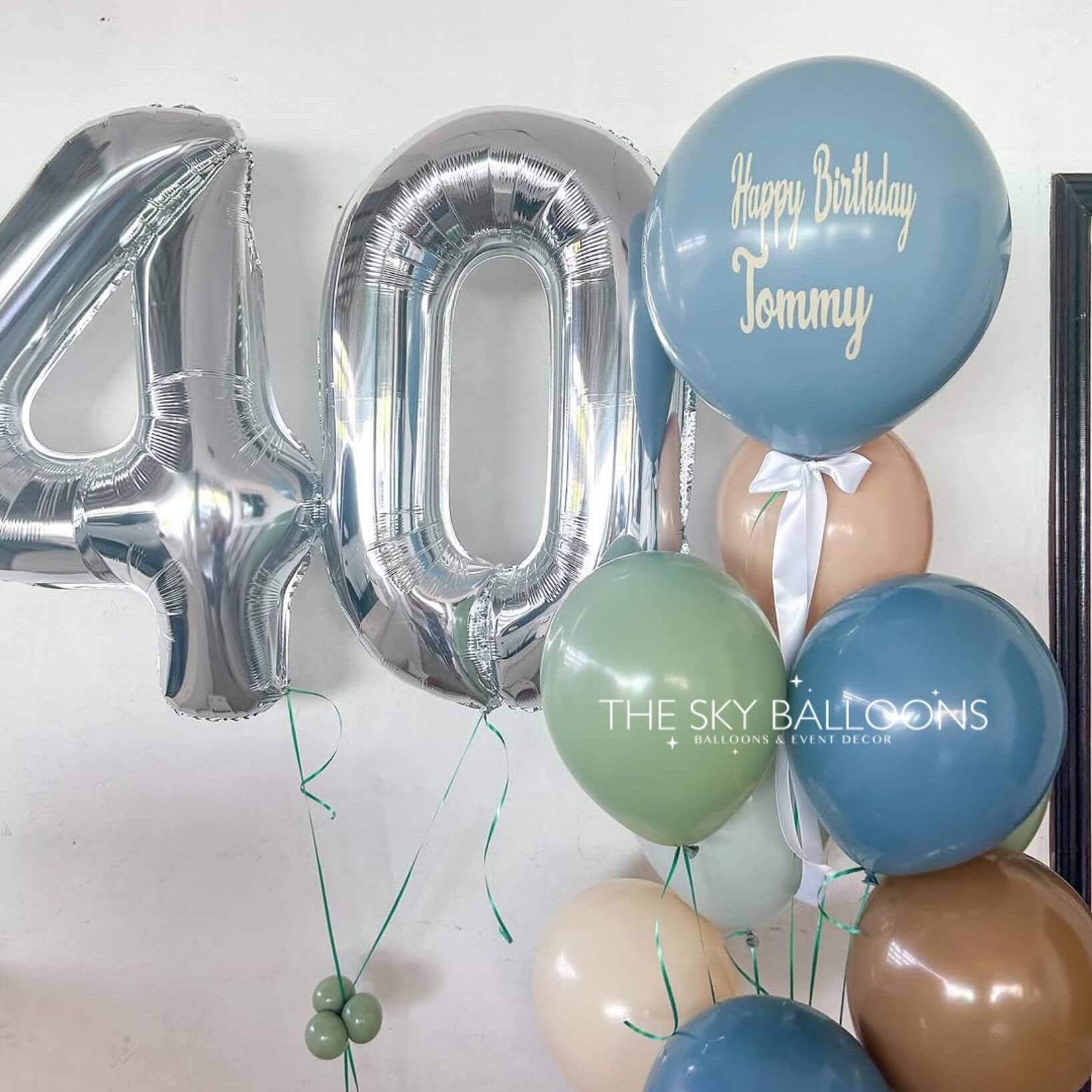 A colorful birthday balloon bouquet featuring the number 40 prominently displayed among various festive balloons.