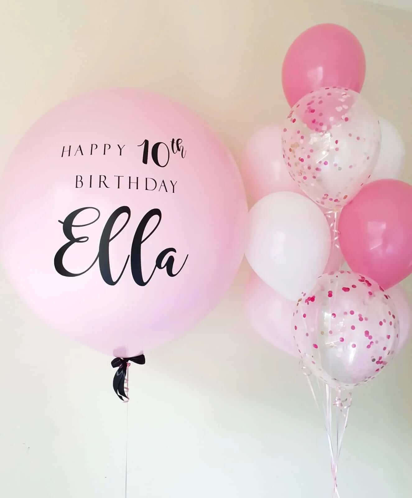 A bouquet of pink and white balloons, with one customized balloon that reads 'Happy 10th Birthday Ella'.