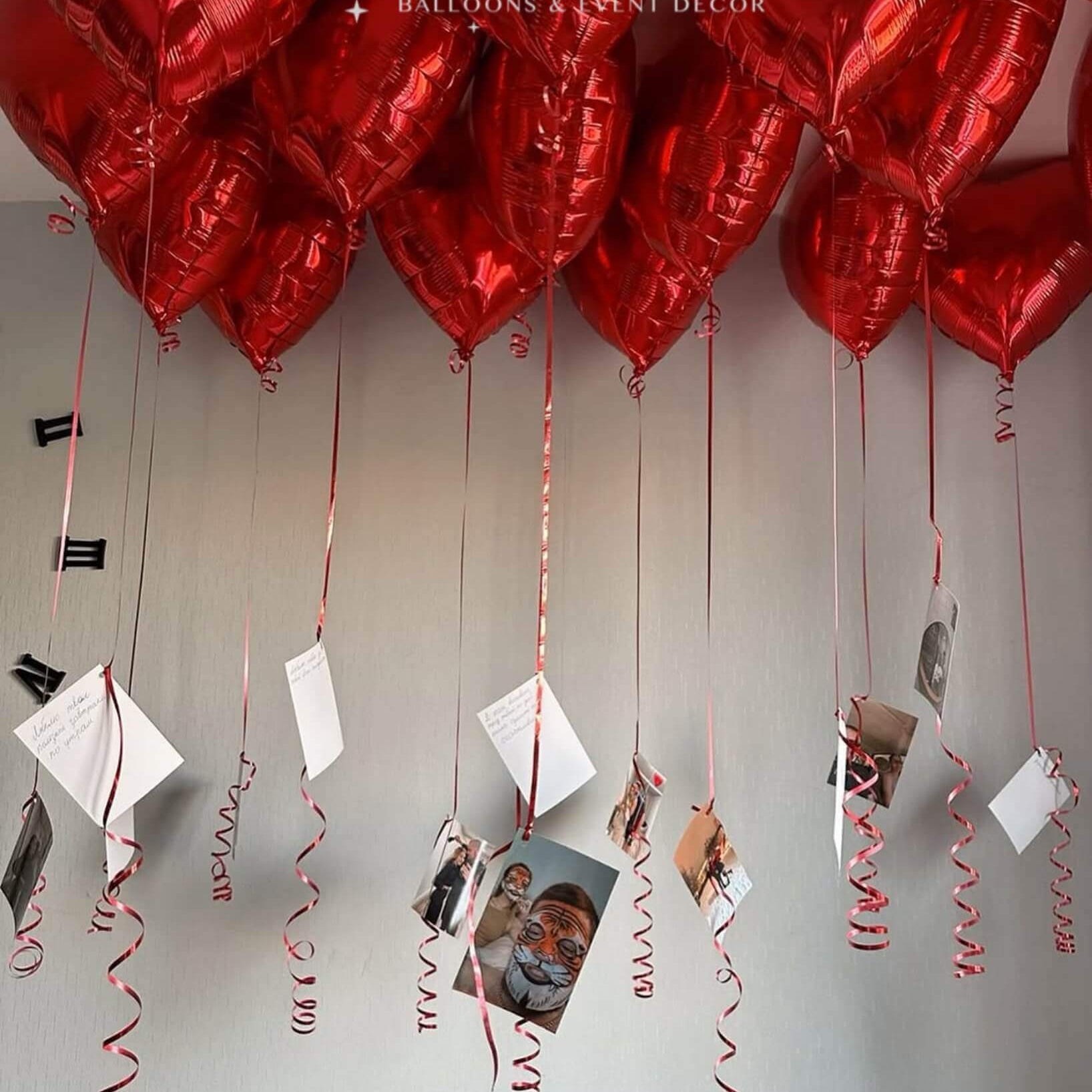 A beautiful arrangement of red heart-shaped helium balloons with attached photo prints and message cards, creating a sentimental and decorative floating display. Perfect for special occasions like birthdays, anniversaries, and romantic surprises.