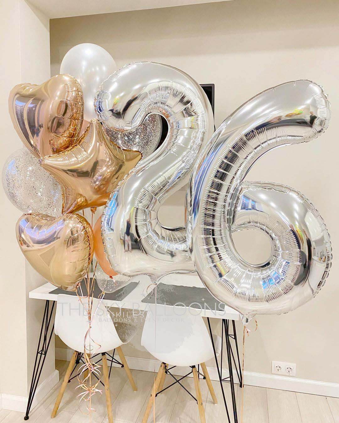 A bouquet of balloons featuring the number 26, with a mix of latex, confetti, heart, star, and number foils in silver, gold, and white colors.