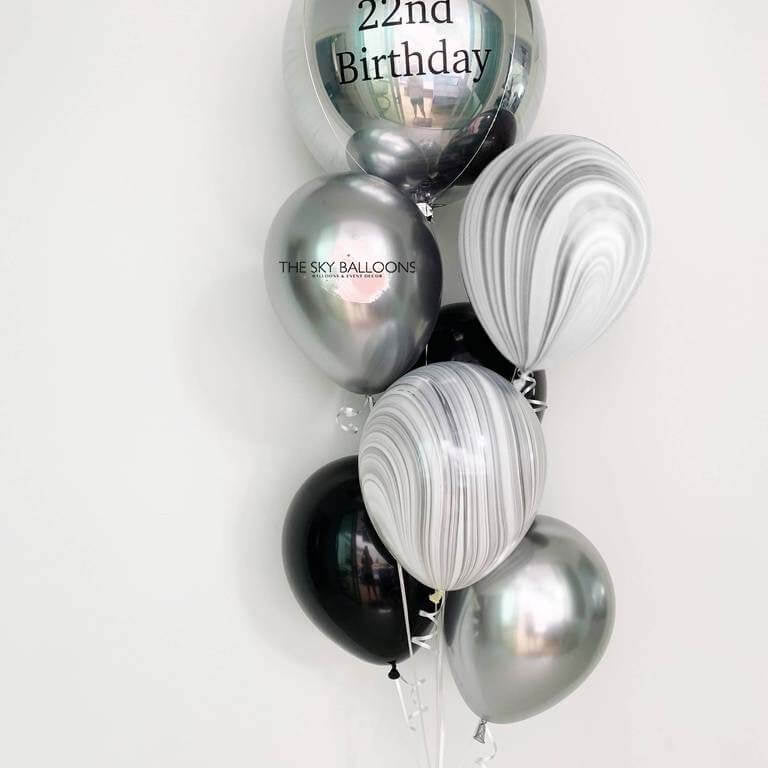 A bouquet of silver and black latex balloons with a customized 'Happy 21st Birthday' orbz balloon among them, all uninflated and displayed against a white background.