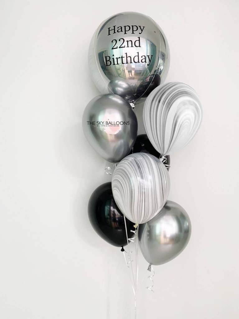 A bouquet of silver and black latex balloons with a customized 'Happy 21st Birthday' orbz balloon among them, all uninflated and displayed against a white background.