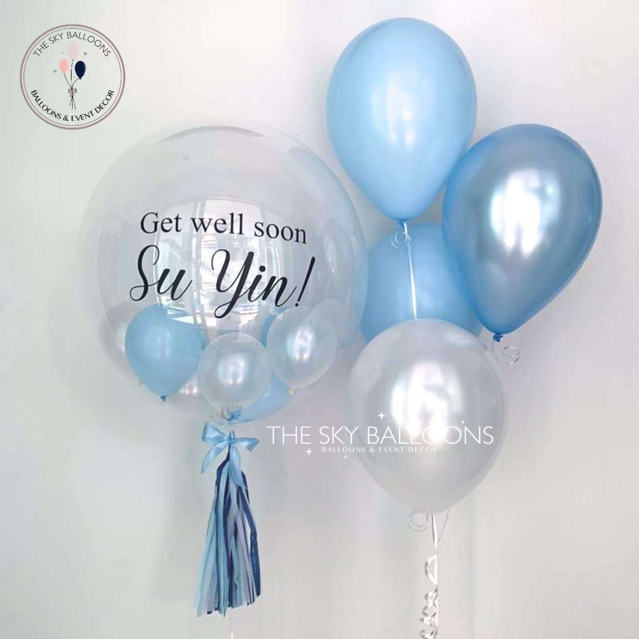 A set of blue latex balloons with 'Get Well Soon' text and a small 'Sui Yin' balloon, tied with a ribbon.