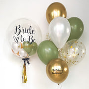 1. A bride-to-be balloon surrounded by gold and green balloons.