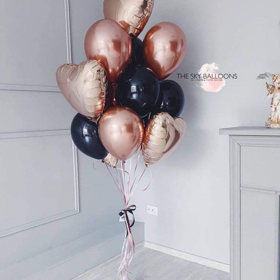 A bouquet of rose gold and black balloons placed near a door, with 'The Sky Balloons' written on the image.