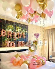 A bed adorned with balloons and a "Bride to Be" sign, creating a festive atmosphere for a special occasion.