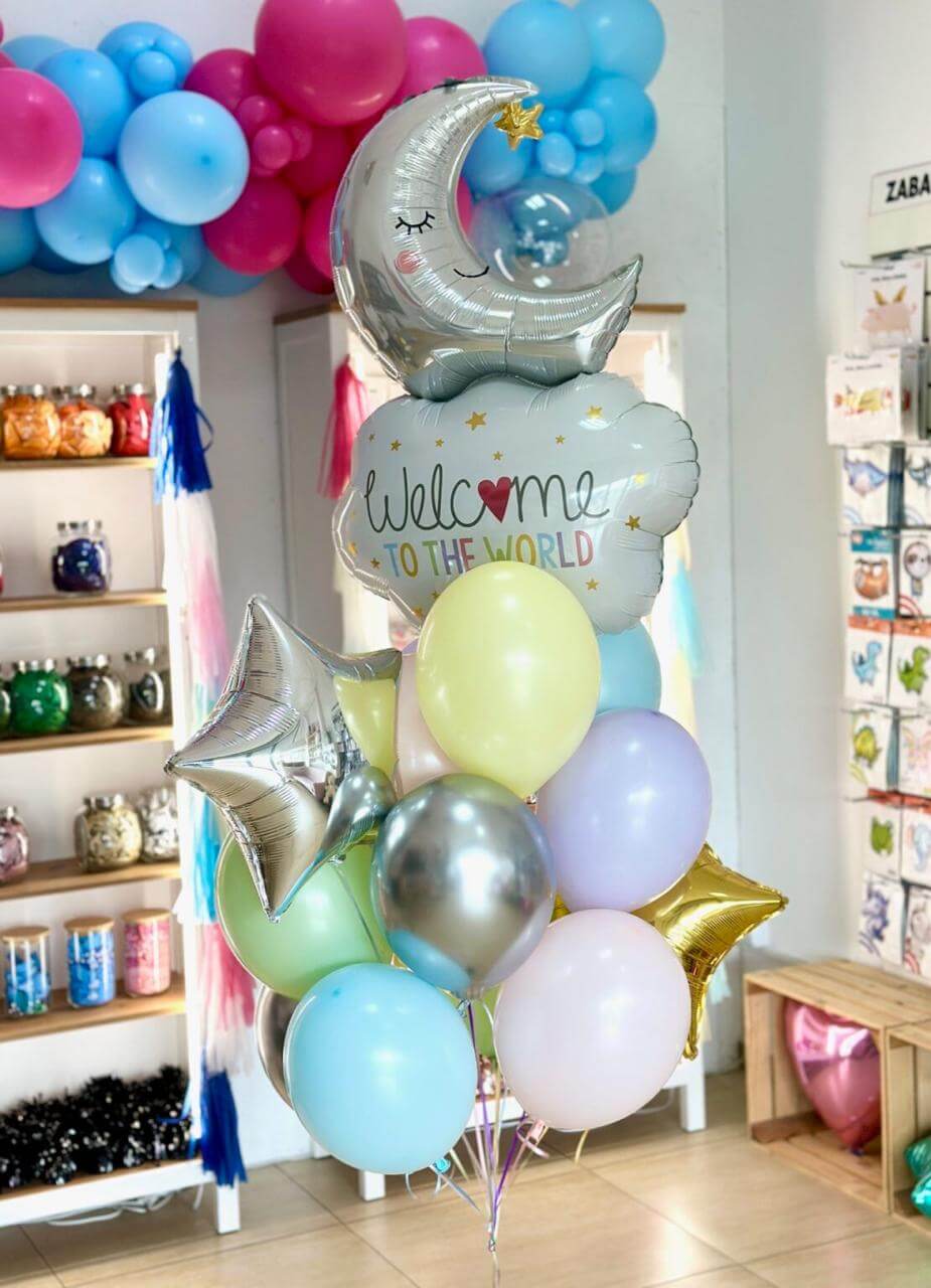 Pink balloon arch with 'Welcome Sofia' text, Christmas tree on right