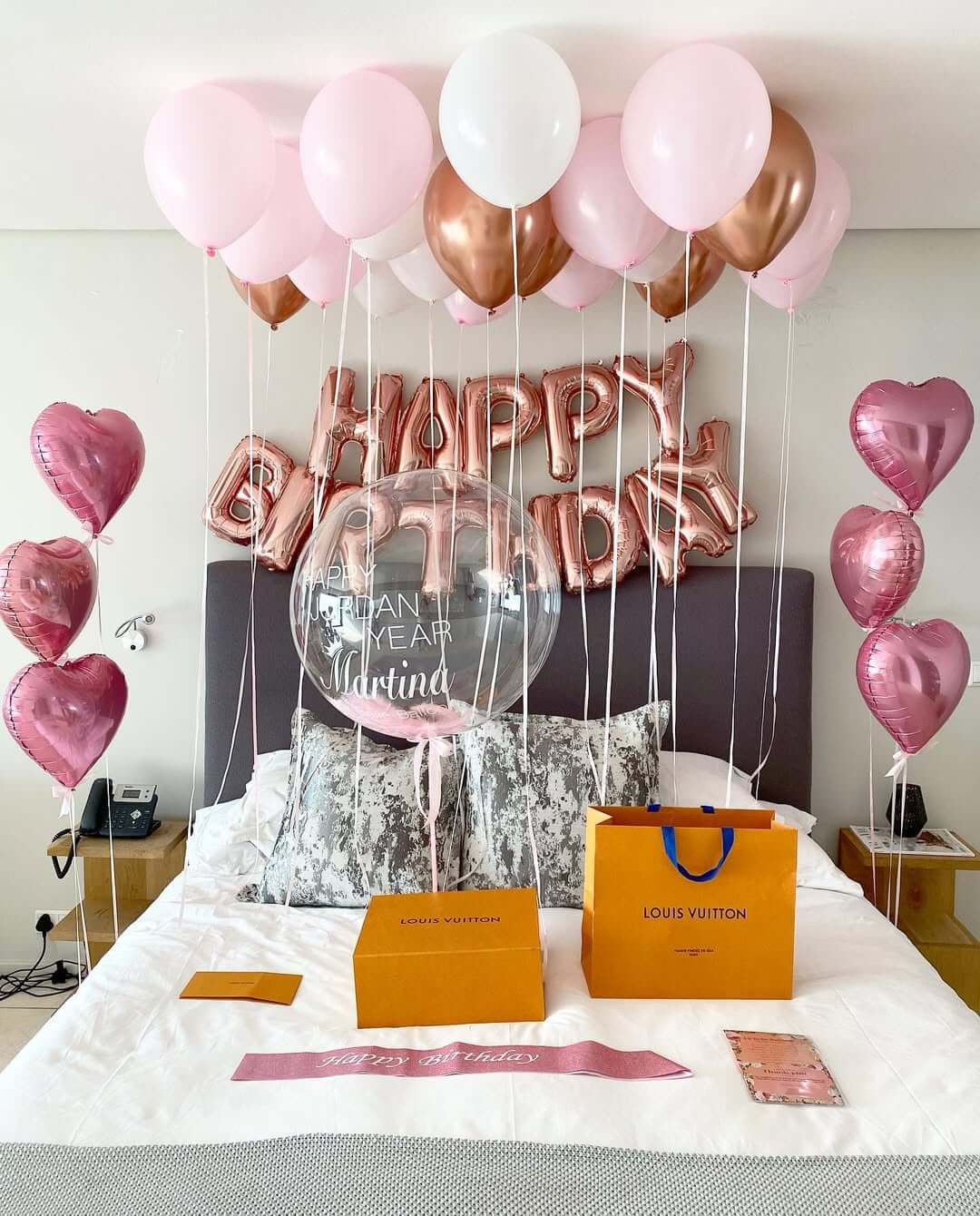 Decorative balloons with 'Happy Birthday 35' on a bed in a room.