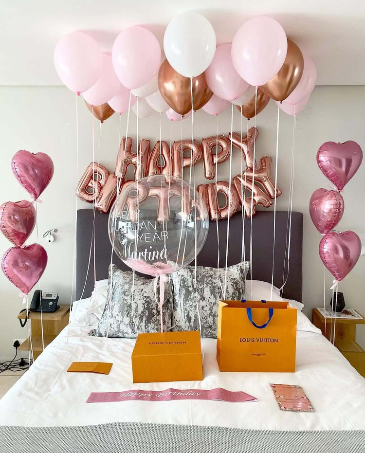 Decorative balloons with 'Happy Birthday 35' on a bed in a room.