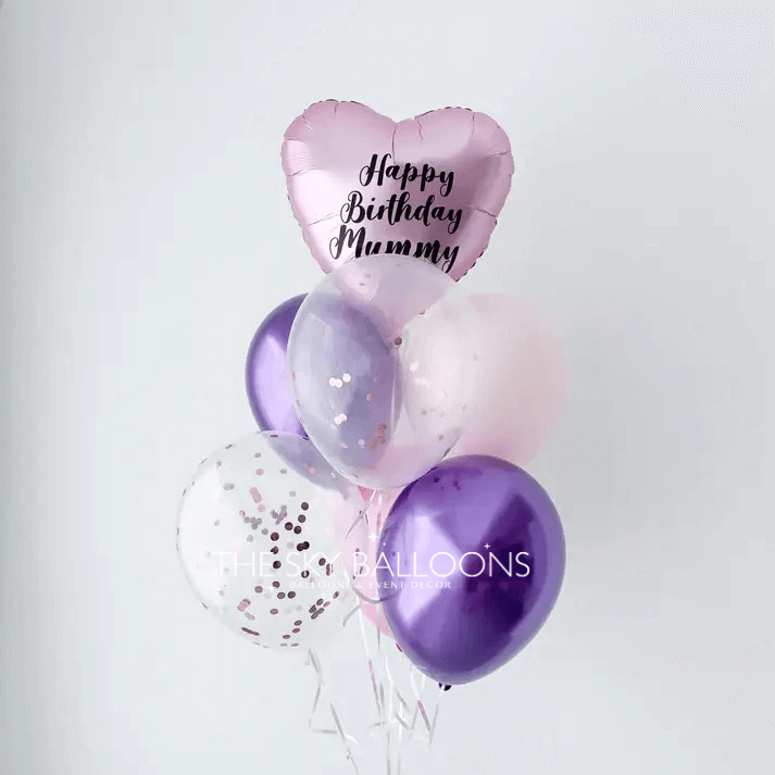 A bouquet of balloons featuring a heart-shaped foil balloon with the text 'Happy Birthday Mummy', three latex balloons in shades of purple and pink, and two confetti-filled balloons.