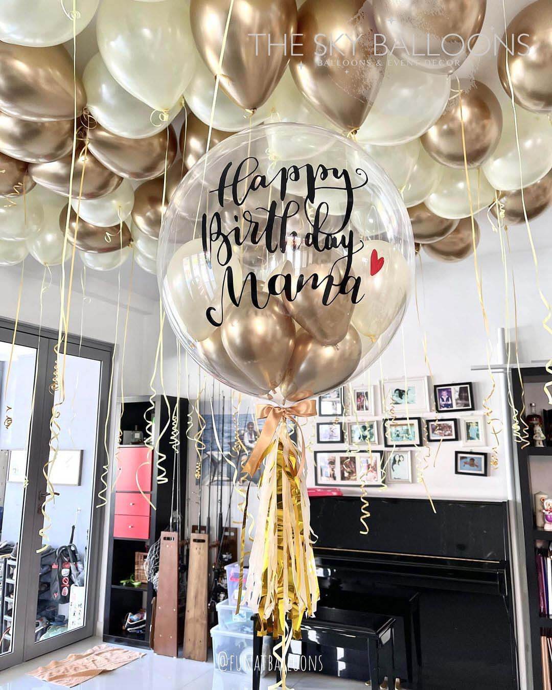 A set of balloons spelling out 'Happy Birthday' with a customized name 'Nathan', in gold and silver colors, displayed in a room.