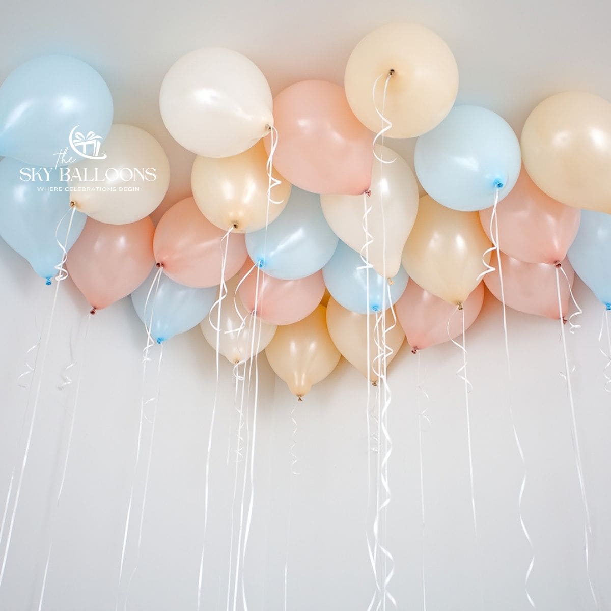 aby-blue, blush-pink, cream and white helium ceiling balloons with hanging white curling ribbons.