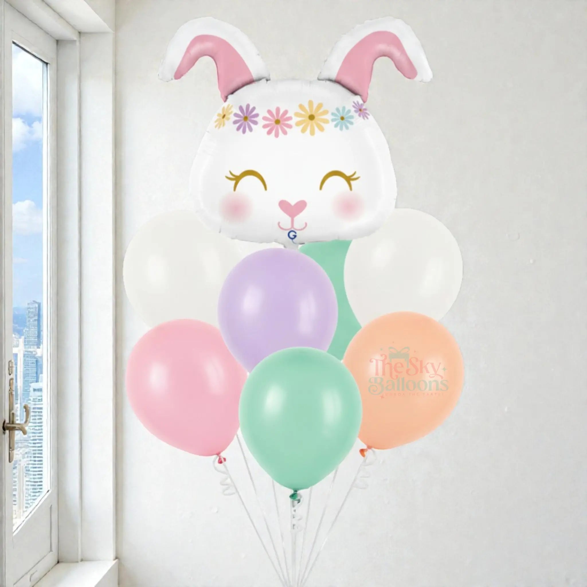 Balloon bouquet shaped like a bunny with pastel balloons in front of a window.