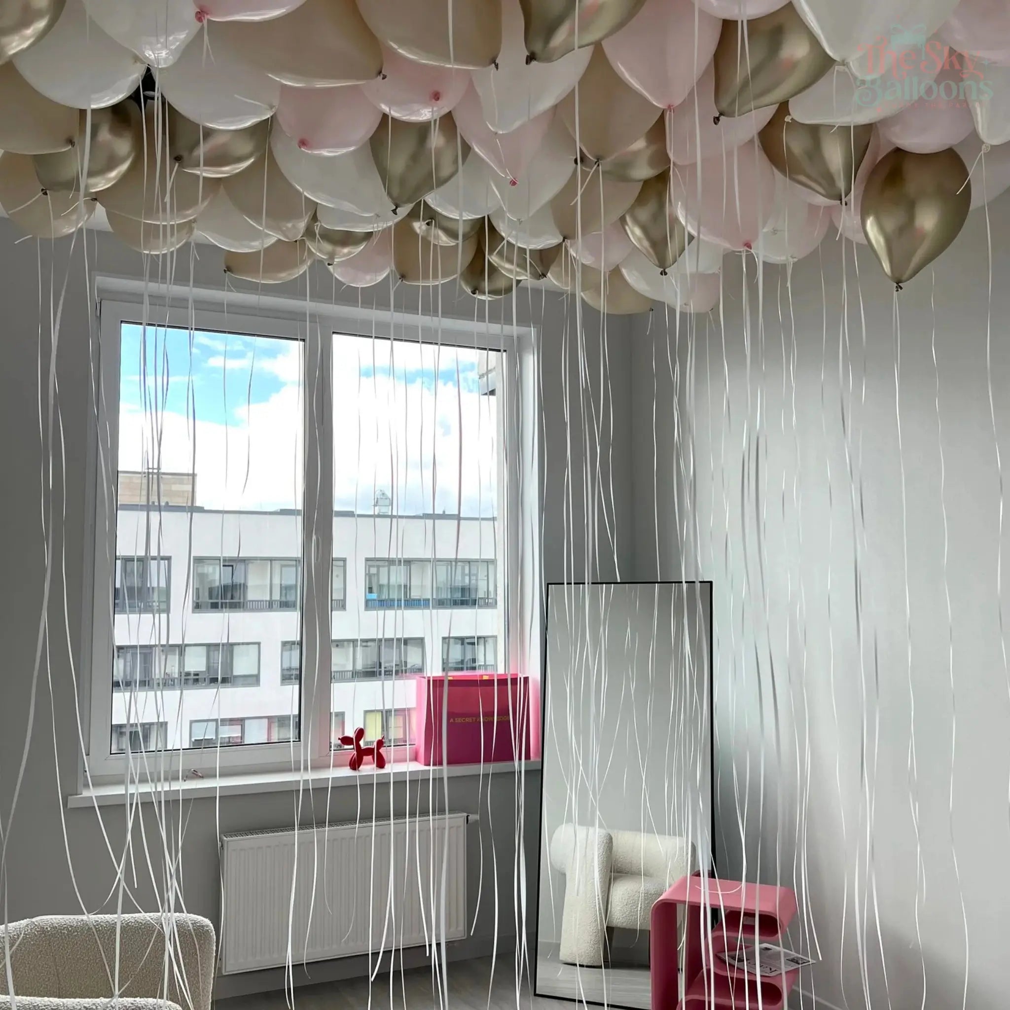 Balloon decorations in a room with a large window.