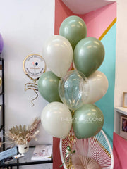 A joyful room filled with green and white balloons, creating a serene celebration.